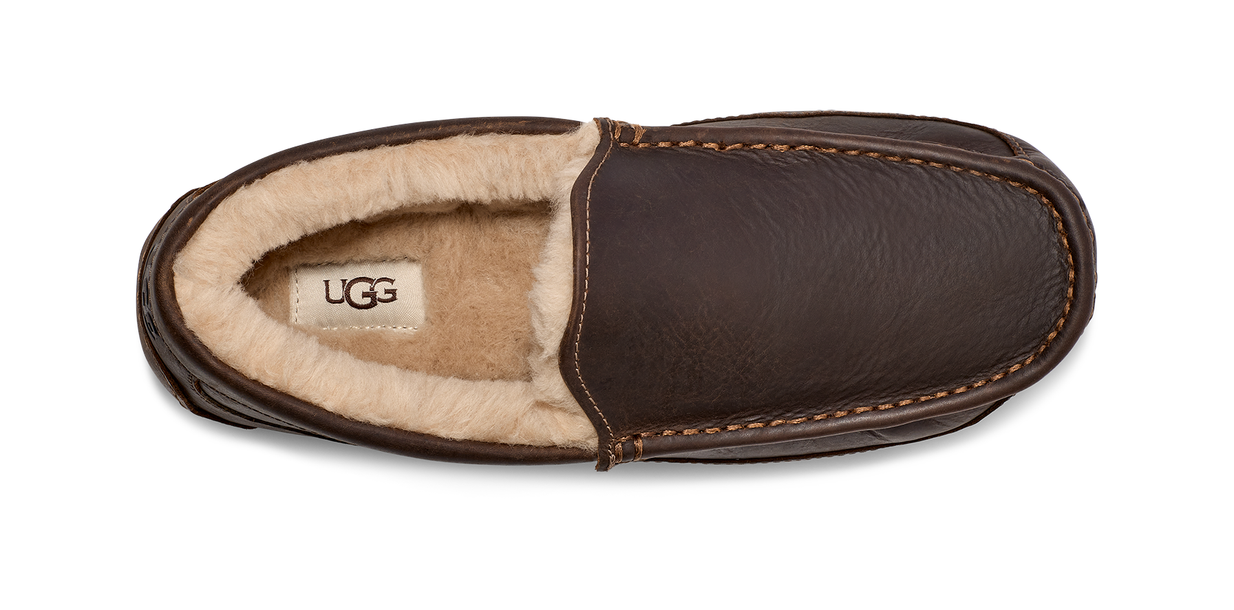 A single UGG slip-on slipper shown from a top-down view, featuring dark brown textured leather on the exterior and a soft cream-colored shearling lining on the interior.