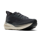 Black running shoe with beige sole on a white background