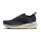 A Brooks running shoe in dark gray and black with a thick cream-colored midsole, shown from a side profile on a white background.