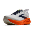 White running shoe with orange sole on a white background