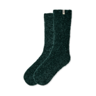 A pair of dark forest green fuzzy socks with a small white brand tag on the cuff, displayed against a solid white background.