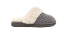 A single knit slipper with a chunky gray knit upper, a soft cream faux-fur trim, and a dark brown sole, shown in profile against a white background.