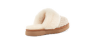 A single slip-on mule slipper shown from the side on a plain white background. The shoe features a fluffy cream faux-fur upper, a beige woven textile side panel, and a tan platform sole.