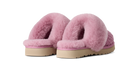 A pair of pink fuzzy slip-on slippers with a textured knit base and beige soles, shown against a plain white background.
