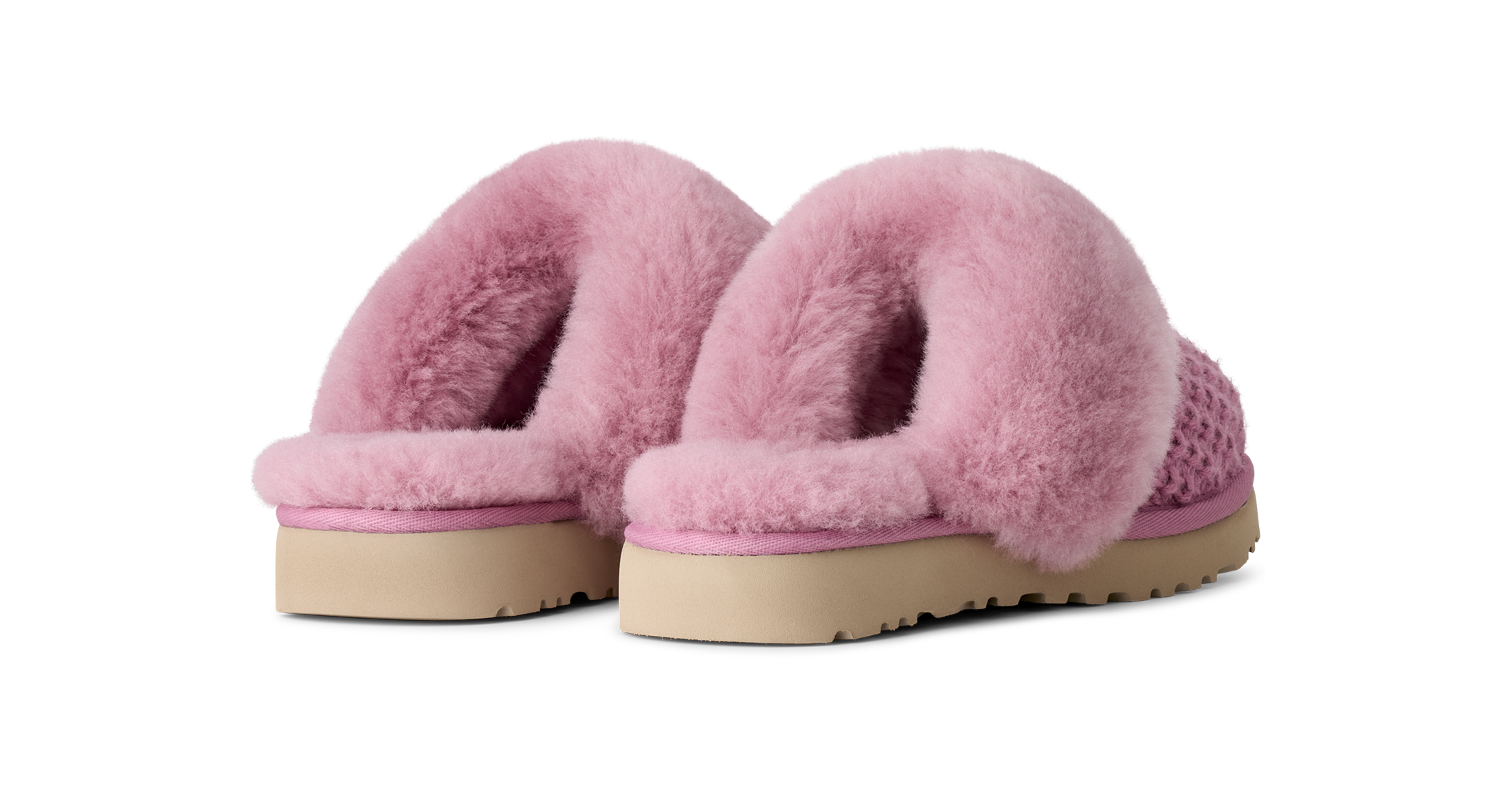 A pair of pink fuzzy slip-on slippers with a textured knit base and beige soles, shown against a plain white background.