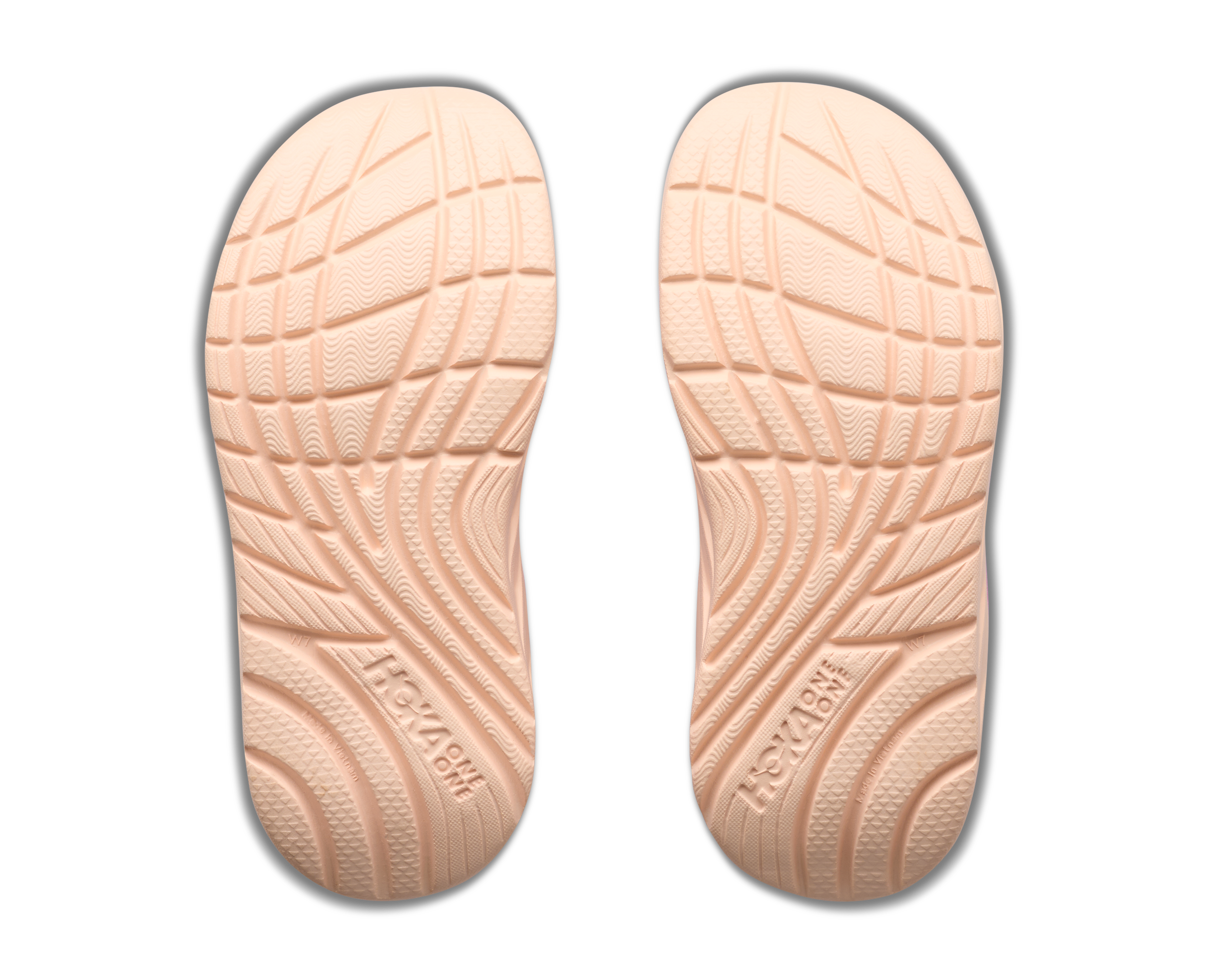 Pair of beige shoe insoles with textured surface on a white background