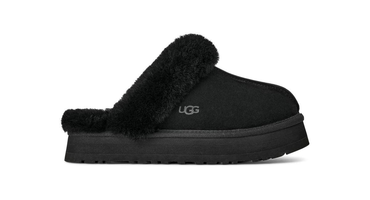 A single black UGG slip-on mule slipper with a plush black faux-fur collar and a thick black platform sole, shown from the side on a white background.