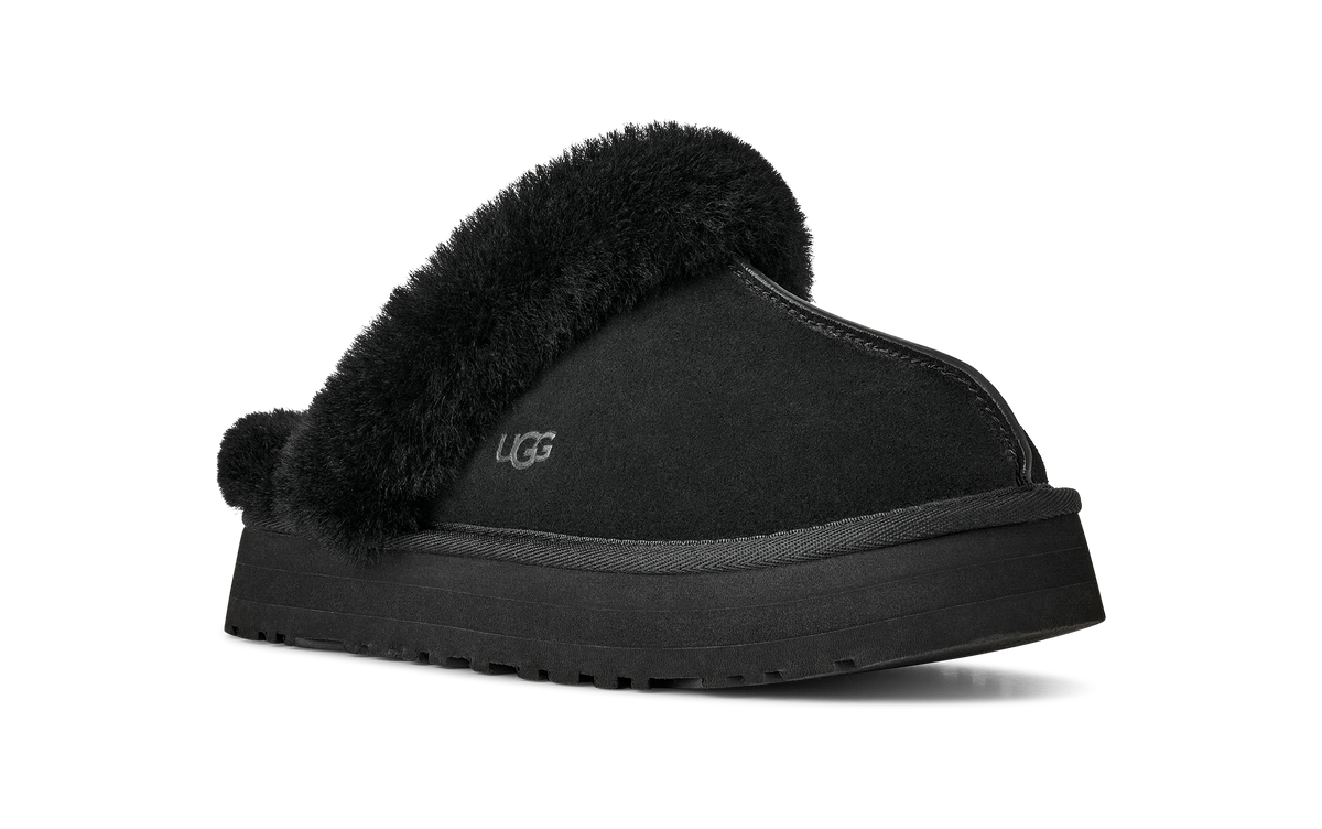 A single black UGG slipper with a thick black platform sole and fluffy black faux-fur trim, shown from a side angle on a white background.