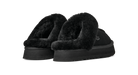 A pair of black UGG slip-on slippers with plush faux-fur trim and thick platform soles, shown against a solid white background.