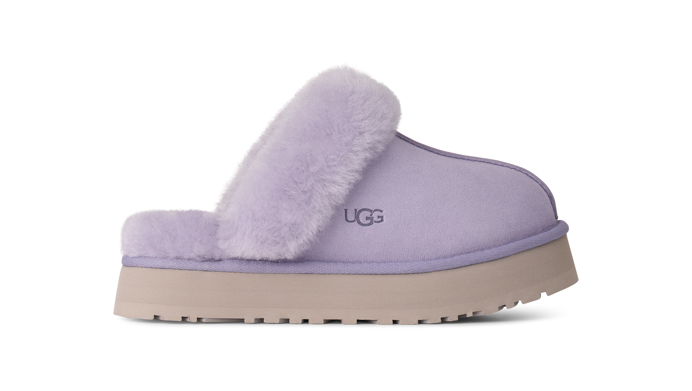 A single UGG slip-on mule slipper in light lavender purple, featuring a soft fuzzy shearling collar and a thick beige platform sole, shown against a plain white background.