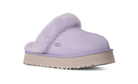A single UGG slip-on mule slipper in light lavender suede with a fluffy lavender faux-fur collar and a beige platform sole, shown from a side profile on a white background.