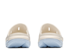 Pair of beige clogs with light blue soles on a white background