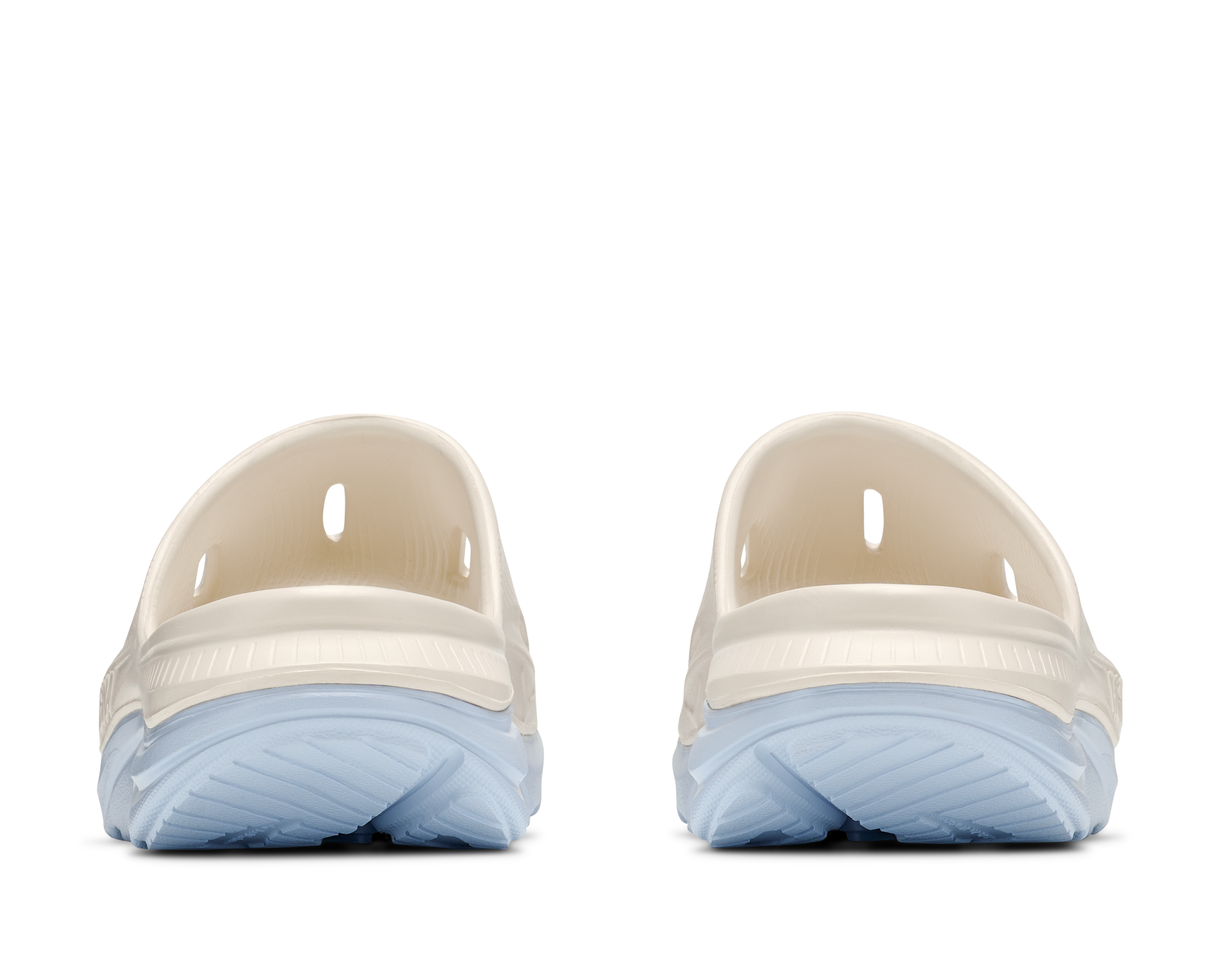Pair of beige clogs with light blue soles on a white background