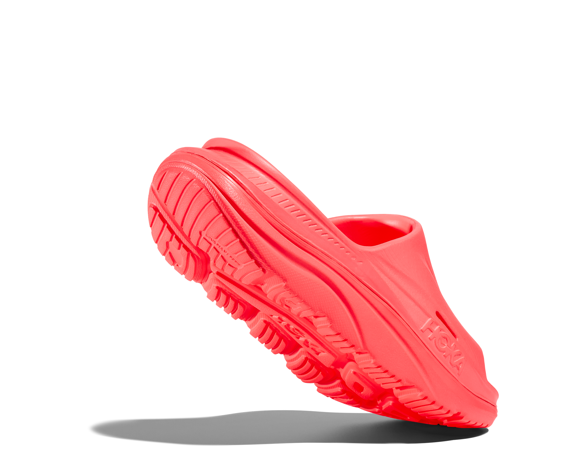 Red slip-on shoe with a textured sole on a white background