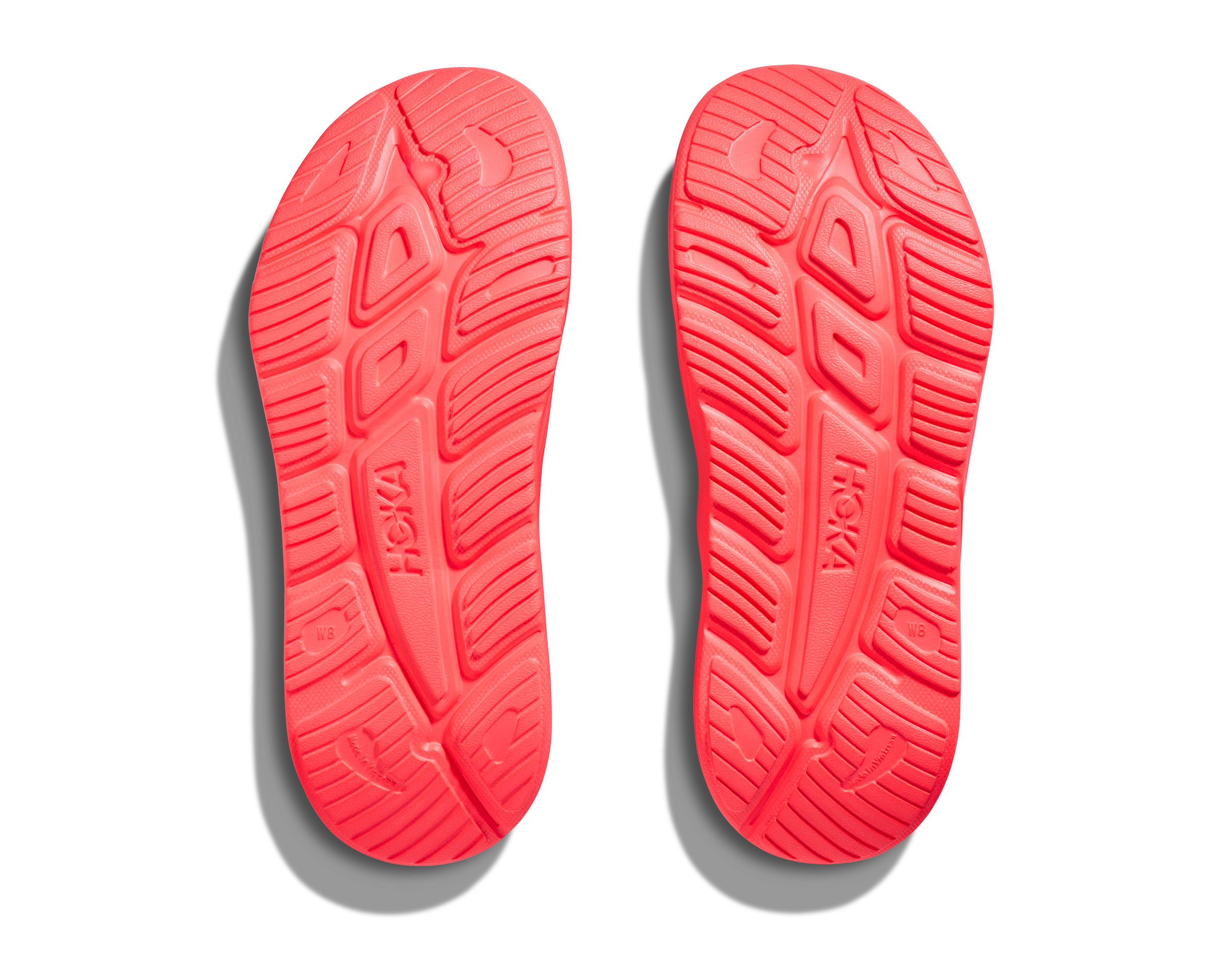Red shoe soles with 'Hoka' branding on a white background
