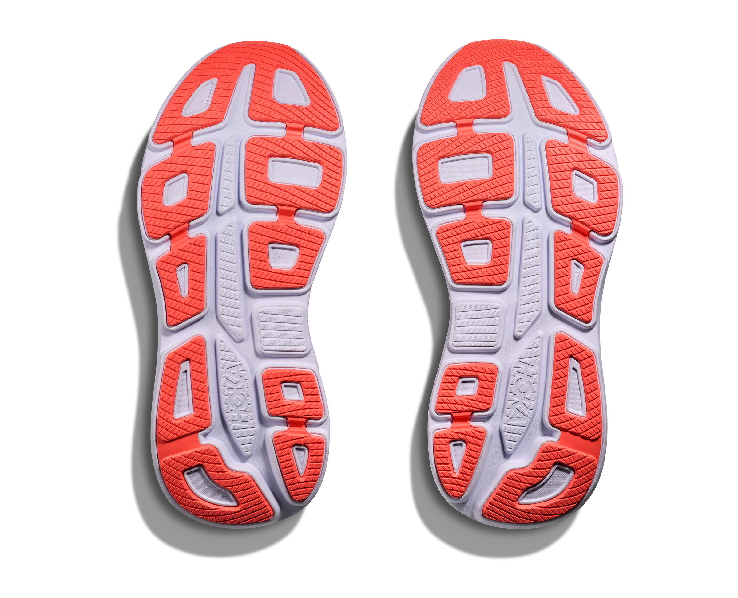 Close-up of a pair of running shoes with red and white sole pattern on a white background