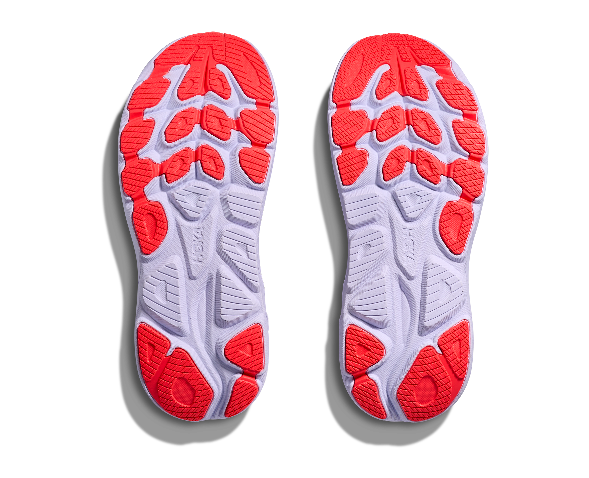 Close-up of a pair of red and gray athletic shoe soles on a white background