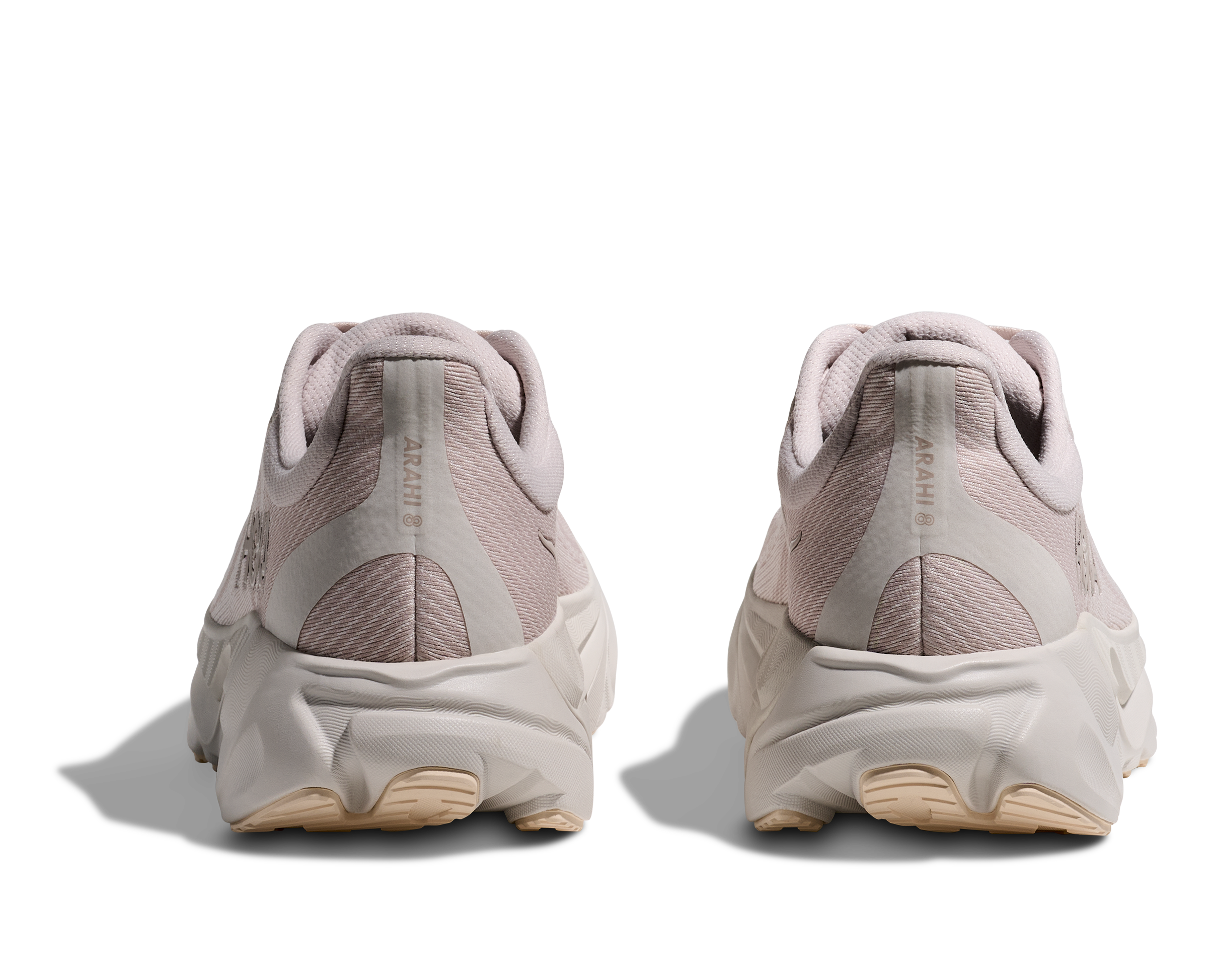 Pair of light pink sneakers shown from the back on a white background