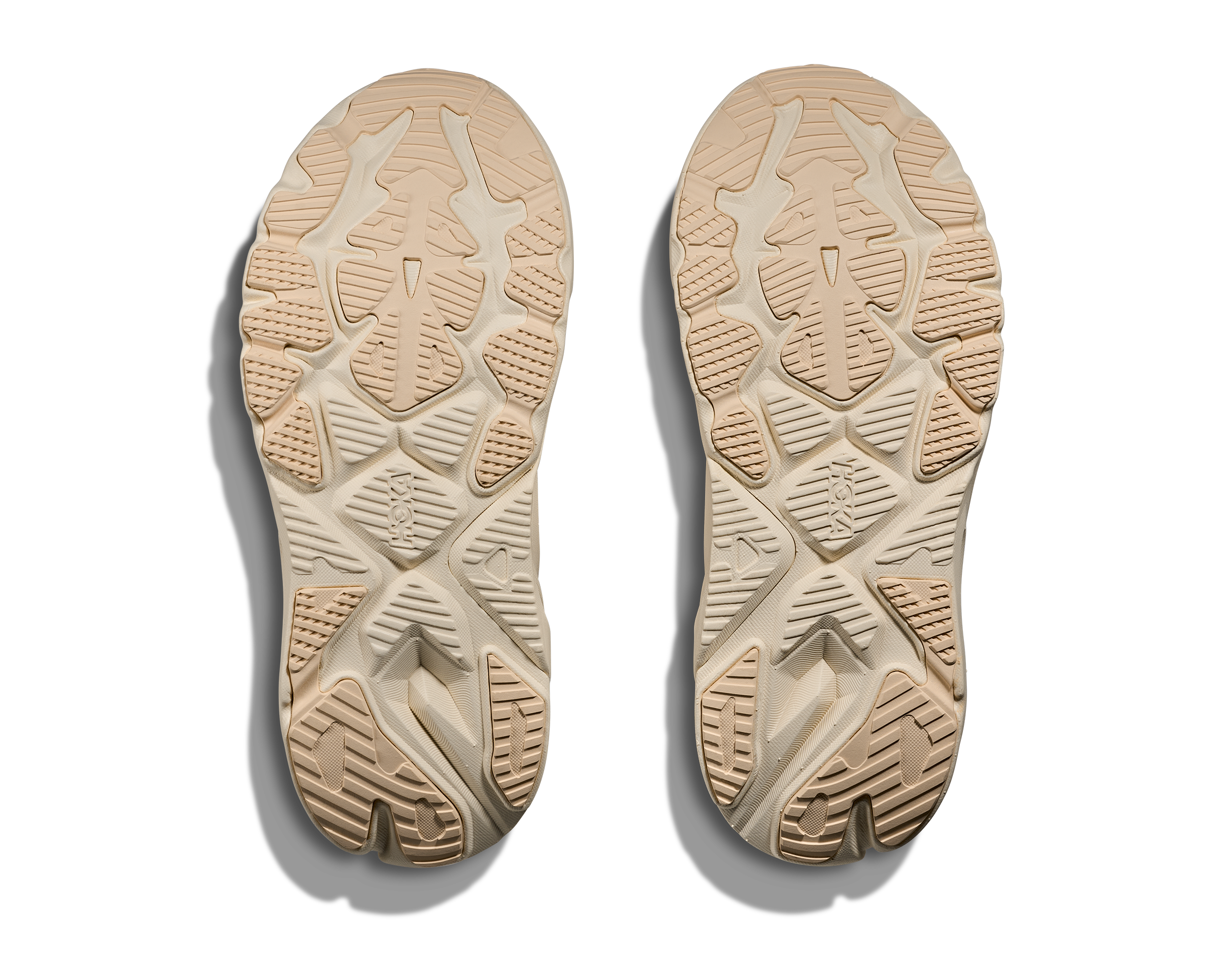 Beige shoe soles with tread pattern on a white background