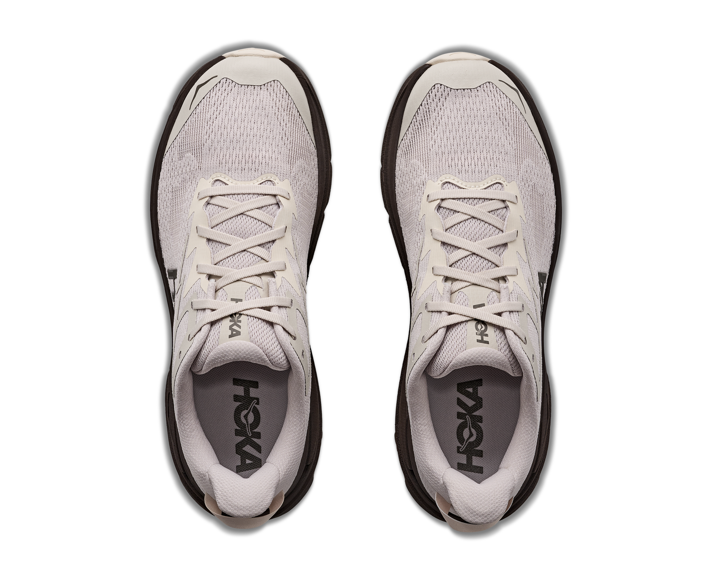 Pair of light gray running shoes with black soles on a white background