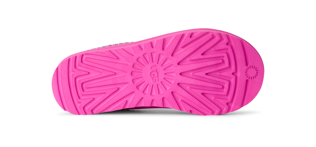 Bright pink shoe sole with a textured radial tread pattern, shown from the bottom against a white background.