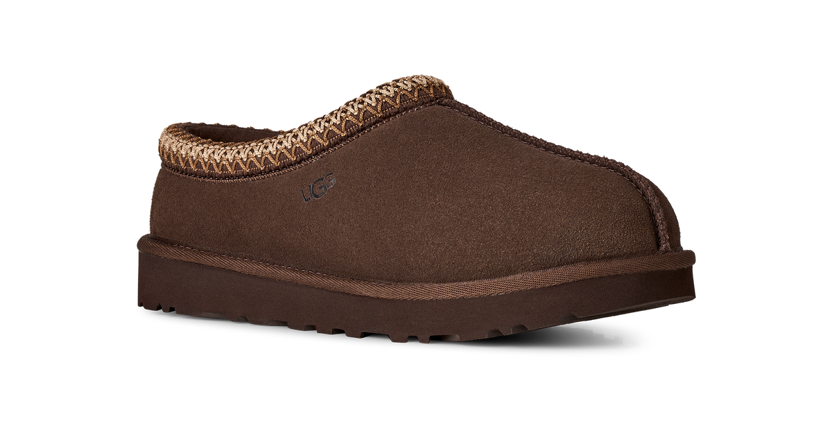 A single brown suede slipper with a braided tan trim around the collar and a thick brown sole, shown from a side profile on a white background.