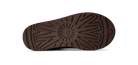 A close-up, top-down view of a dark brown shoe sole, showing its textured tread pattern and a small circular logo near the heel, set against a plain white background.