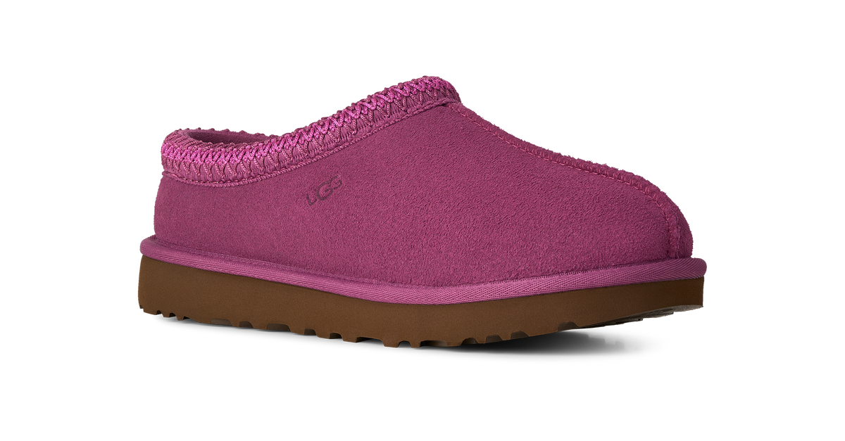 A single UGG slip-on clog shoe in a vibrant magenta pink suede-like material with a matching pink braided trim and a brown rubber sole, shown against a plain white background.