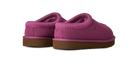A pair of UGG slip-on slippers in a vibrant magenta pink suede and sherpa fabric, featuring a brown gum sole, shown against a plain white background.