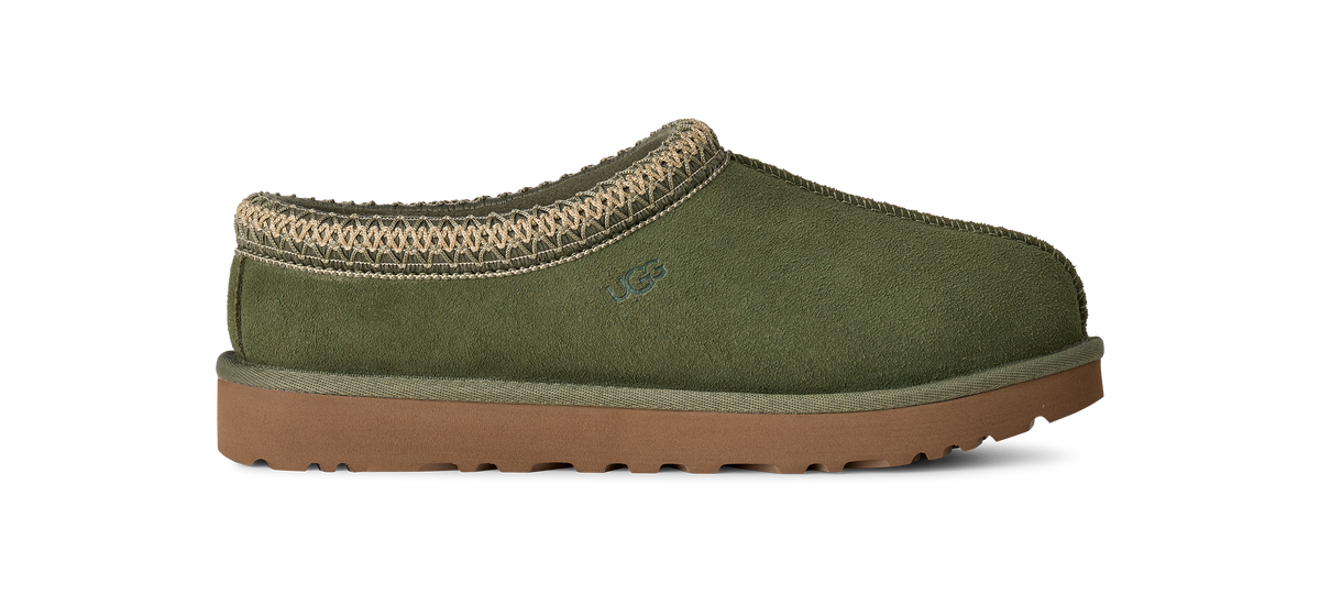 An olive green suede slipper with a tan knit trim and a brown sole, shown from a side profile on a white background.