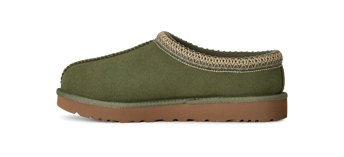 An olive green suede slipper with a brown rubber sole and a beige knit trim around the collar, shown from a side profile on a white background.