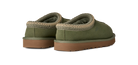A pair of UGG slip-on slippers in olive green suede with a tan braided trim and brown rubber soles, shown from a three-quarters angle on a white background.