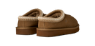 A pair of brown suede slip-on slippers with a textured cream knit trim around the collar and a plush brown lining, shown from a three-quarters angle on a white background.