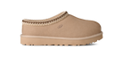 Beige slip-on shoe with brown trim on a white background