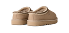 Pair of tan slippers with brown trim on a white background