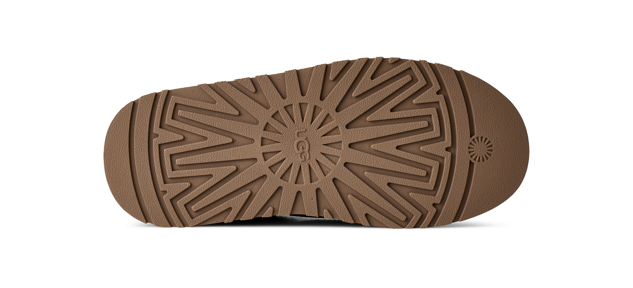 A close-up, top-down view of a brown textured shoe sole, showing the tread pattern and a circular UGG logo embossed in the center, on a white background.