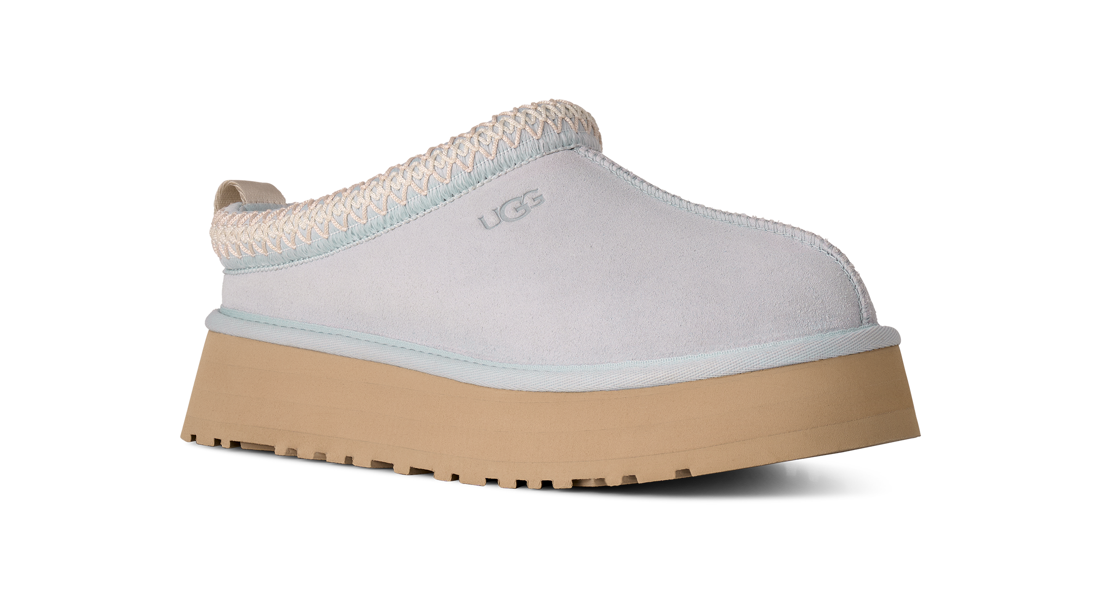 White UGG slip-on shoe with a brown sole on a white background