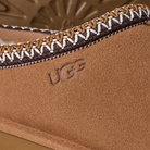 Close-up of a brown UGG boot with decorative stitching detail.