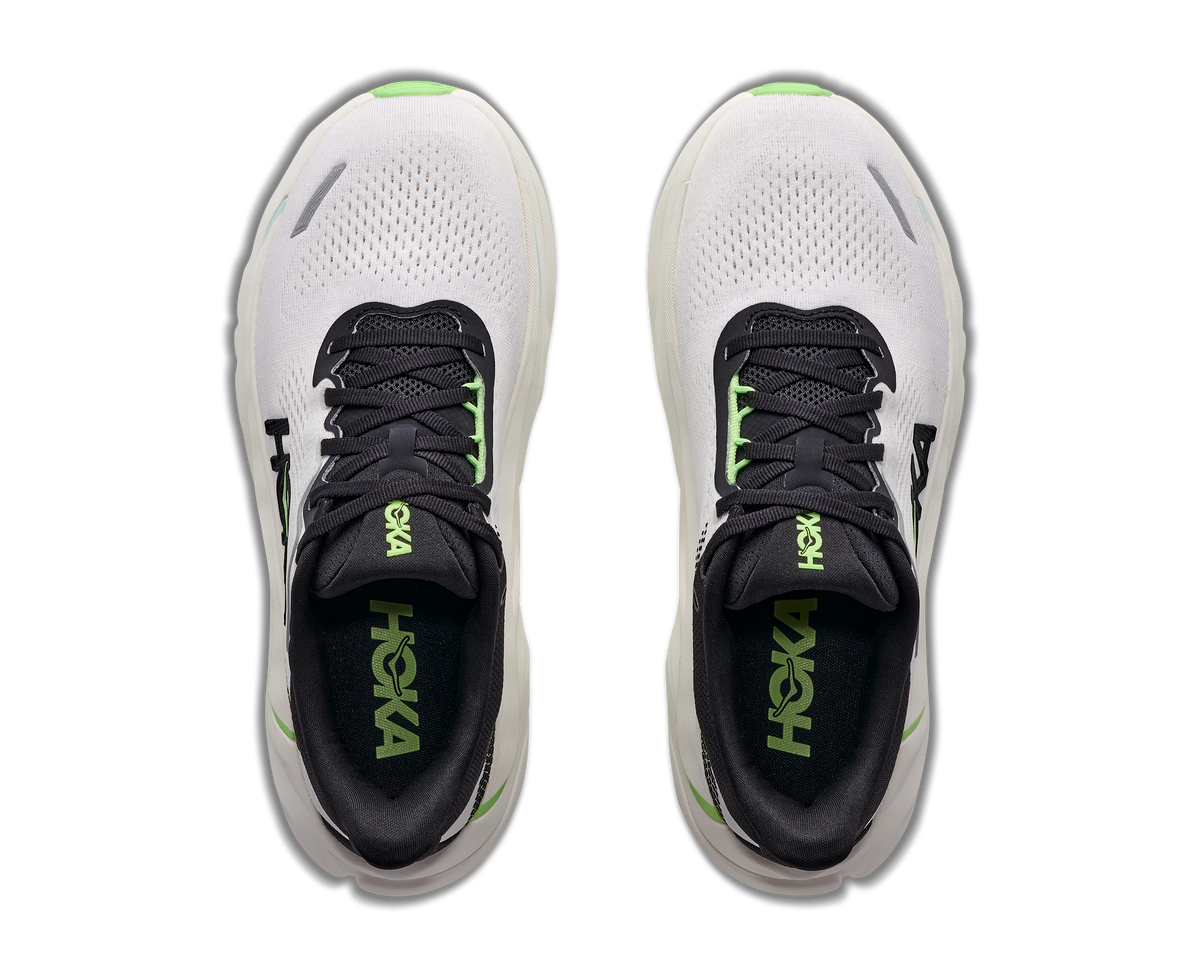 A pair of HOKA running shoes shown from a top-down view, featuring a white mesh upper, black collar and laces, and vibrant neon green accents including the HOKA branding on the tongue and heel.