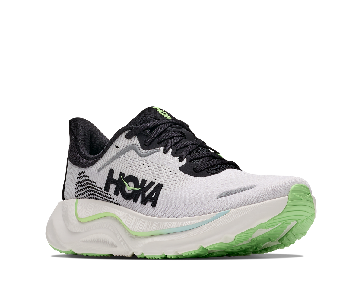 A HOKA running shoe in white, black, and neon green, shown from a lateral side profile view against a plain white background.