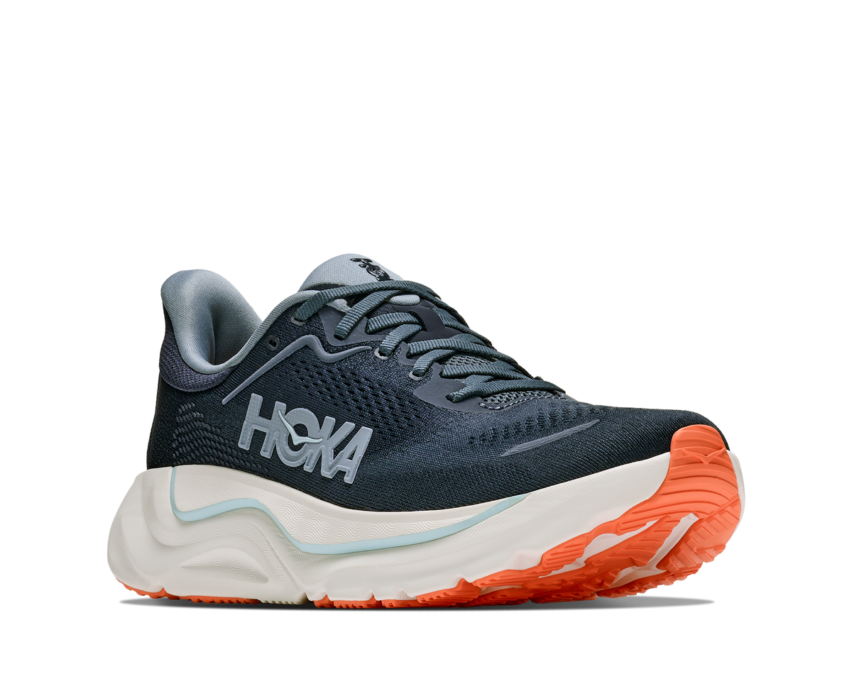 Navy running shoe with orange sole on a white background