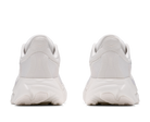 A pair of white chunky sneakers shown from the back, featuring textured mesh uppers and thick sculpted white soles, set against a plain white background.