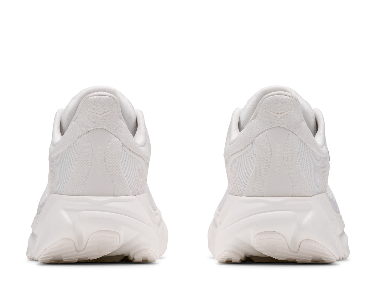A pair of white chunky sneakers shown from the back, featuring textured mesh uppers and thick sculpted white soles, set against a plain white background.