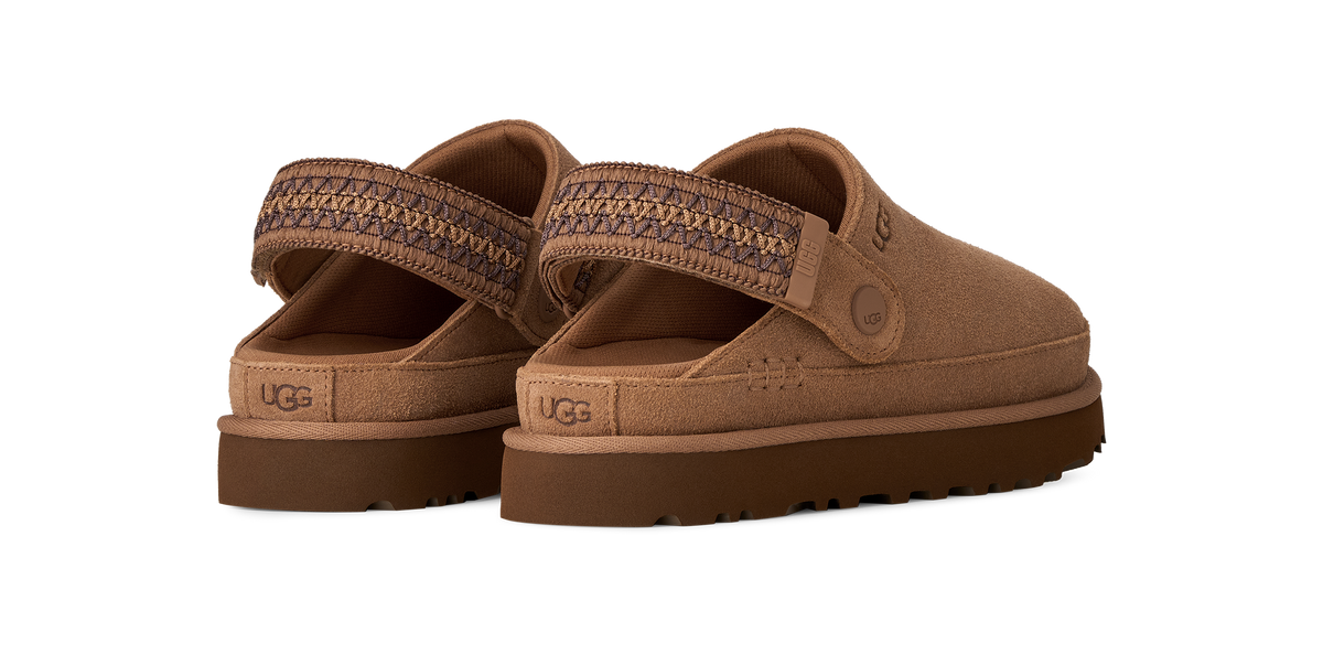 A pair of UGG slip-on clogs in a warm brown suede-like material, featuring a patterned woven strap and a thick brown sole, shown against a solid white background.