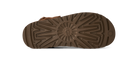 The brown rubber outsole of a boot, showing a detailed tread pattern and a small embossed logo on the heel, photographed against a solid white background.