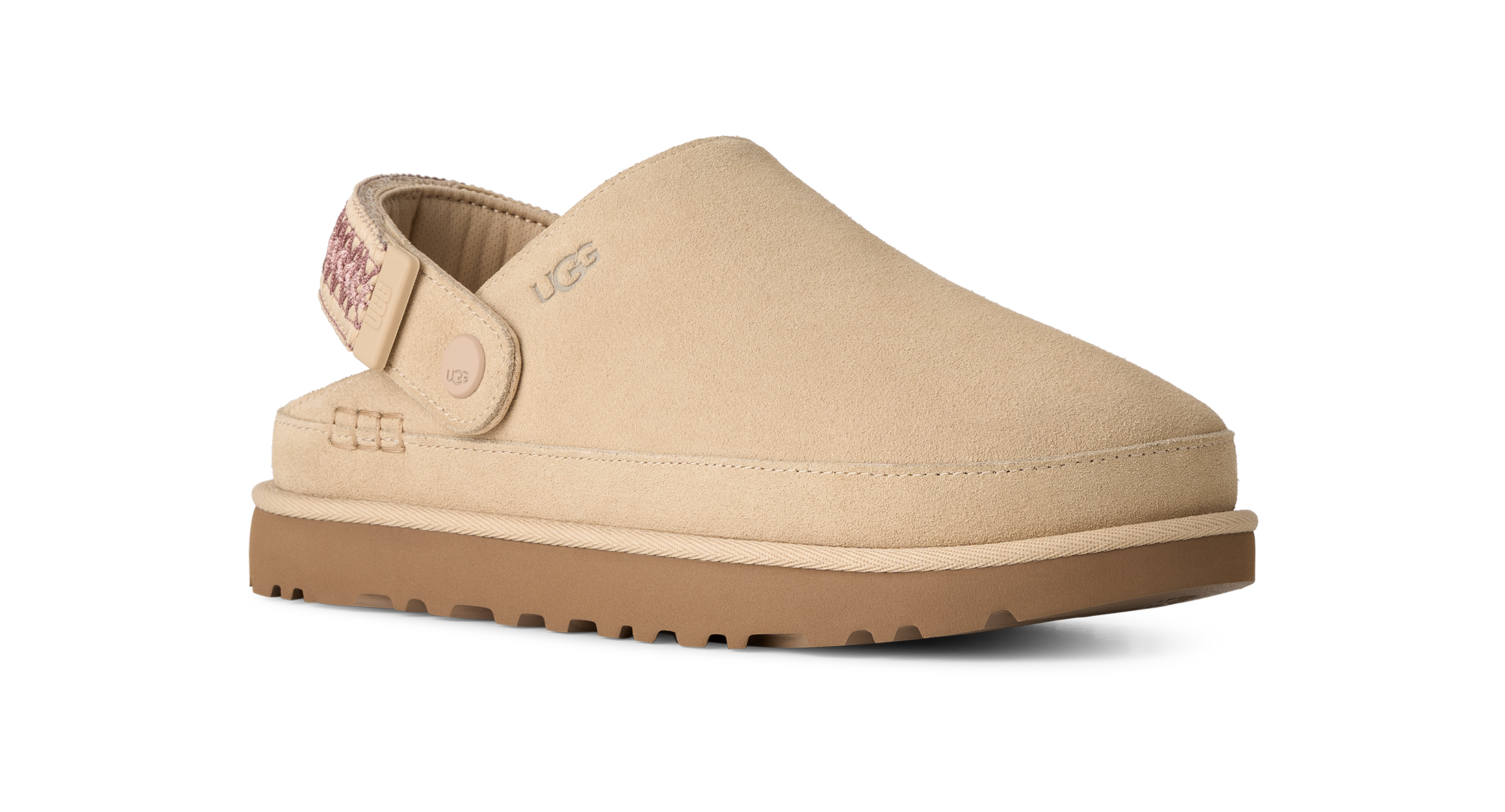 A beige UGG slip-on clog shoe with a tan sole, shown from a side profile on a white background.