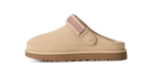 A beige slip-on clog-style shoe with a brown sole and a pink patterned strap detail, shown in profile against a white background.