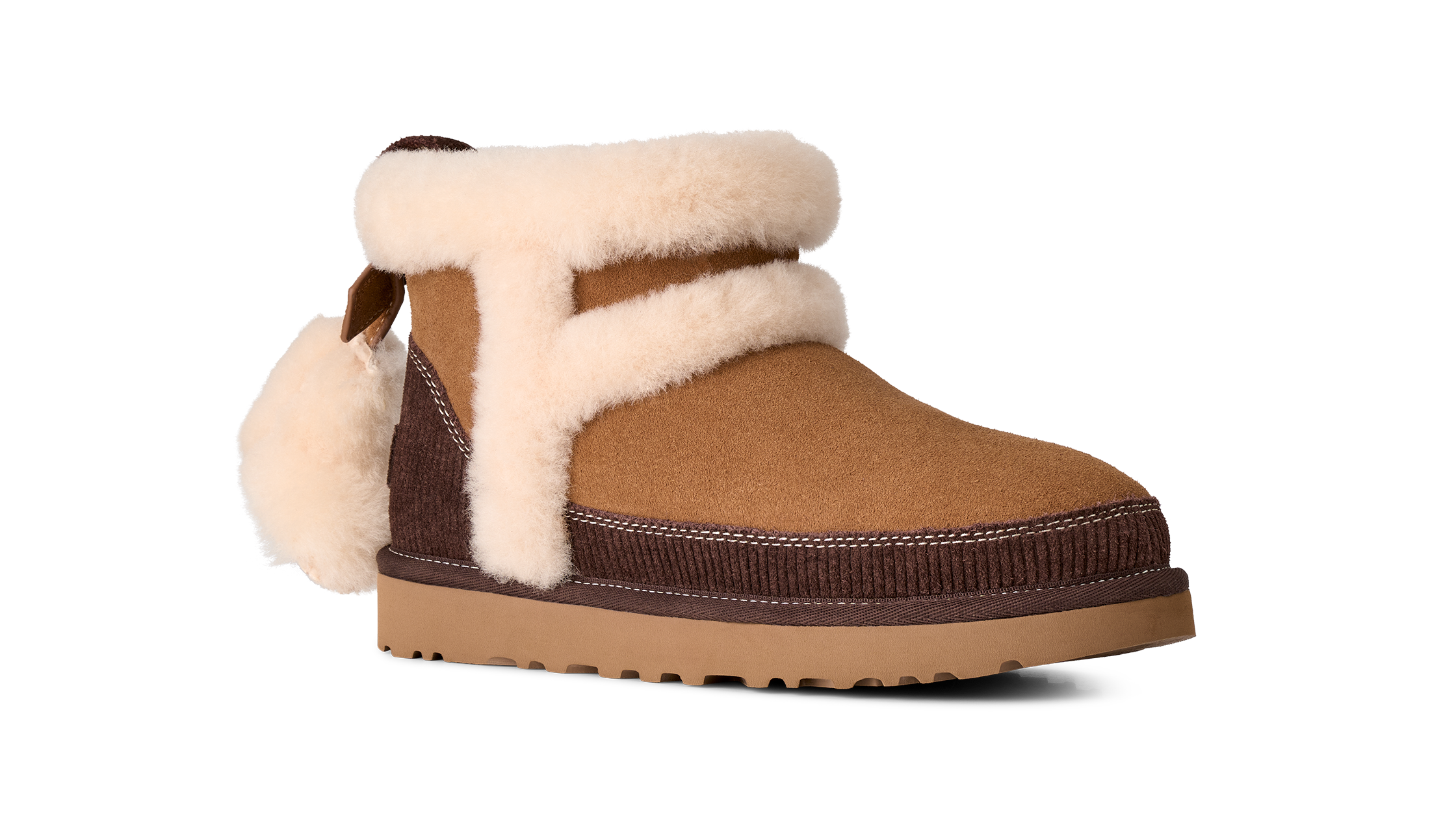 A brown suede ankle boot with thick cream shearling-style trim and a matching pom-pom, shown from a side profile on a white background.