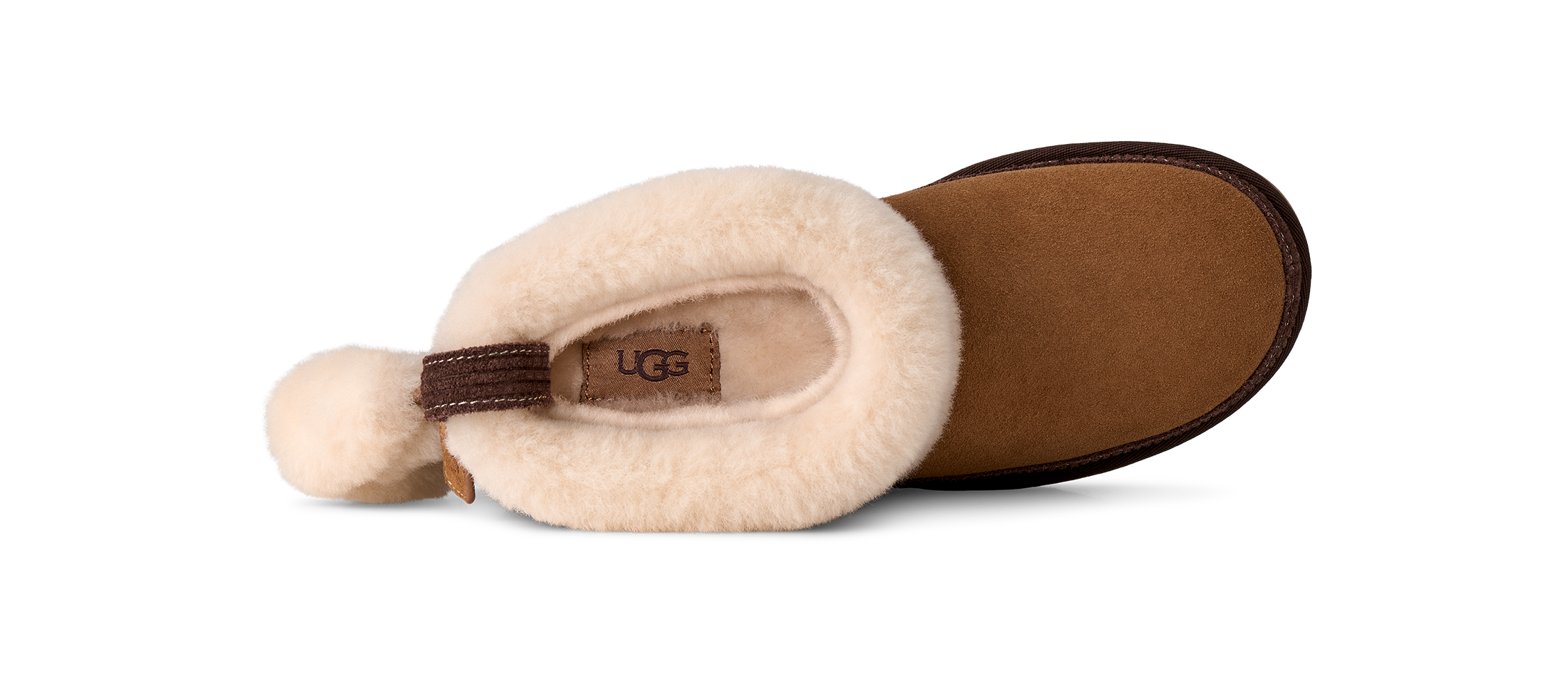 A single UGG slipper shown from a side profile view on a white background, featuring a cream-colored shearling upper, a brown suede-like footbed, and a brown heel pull tab.