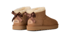 Pair of brown UGG boots with decorative bows on a white background